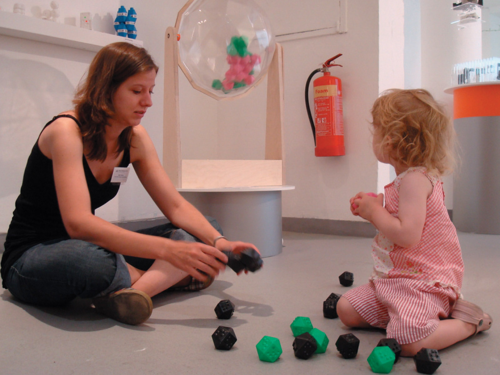 A little girl playing with the self-organising objects in front of the Entropy Machine